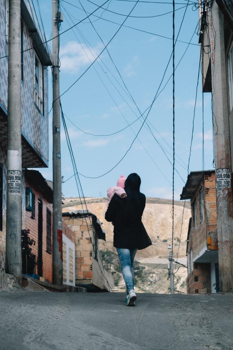 Woman walking with her baby in the streets of Bogota, Columbia.