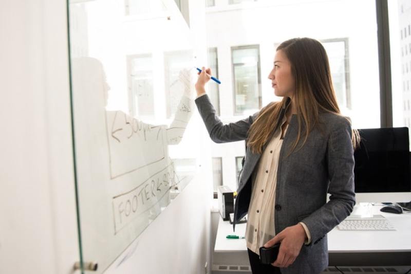woman writing in whiteboard in school