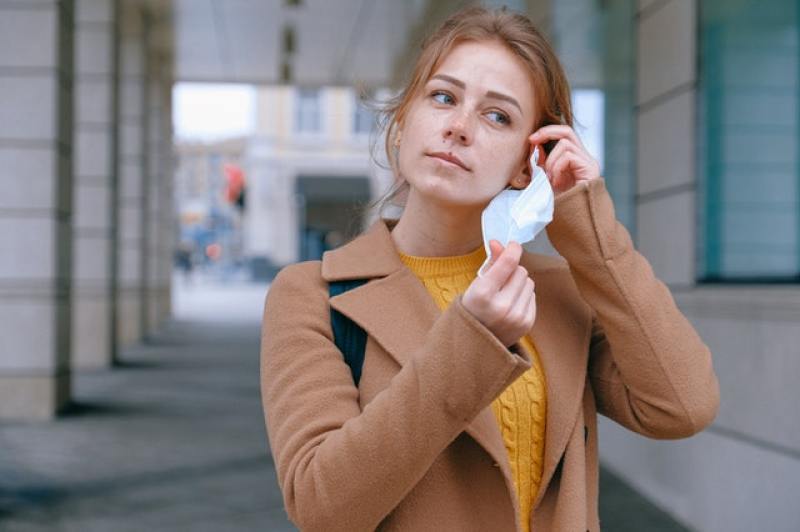woman removing her mask