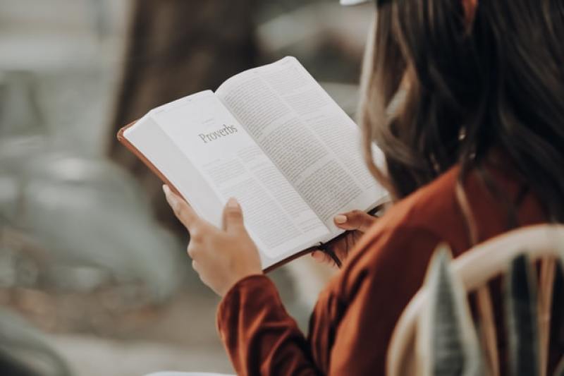 girl reading from the book of Proverbs in the Bible
