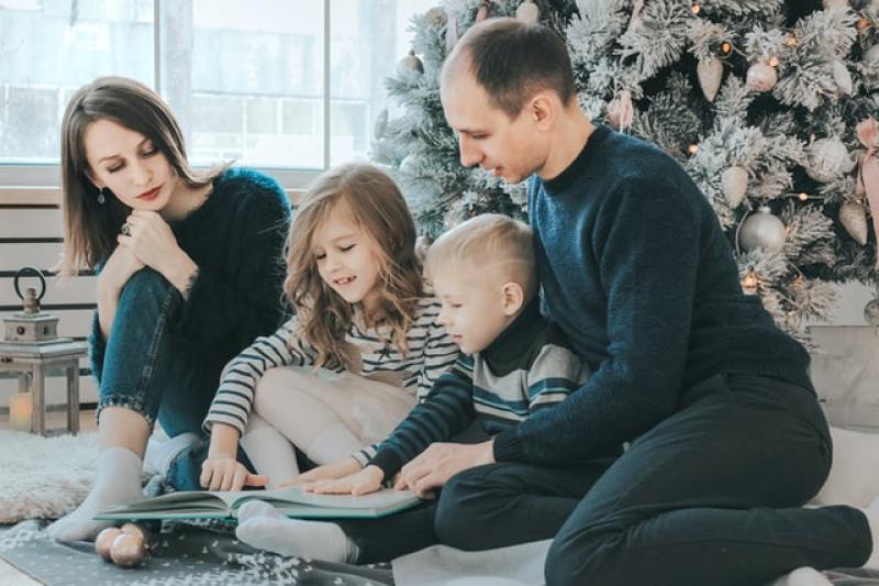 family spending time with each other beside the Christmas tree