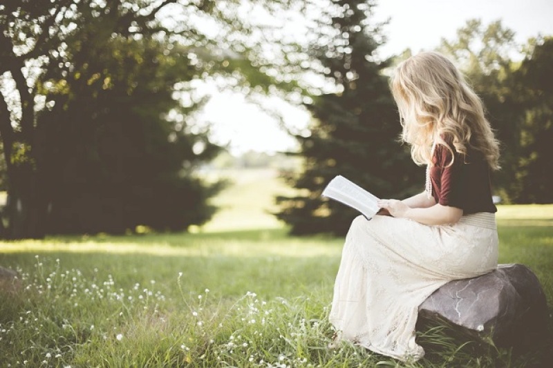 woman reading her Bible alone in a garden