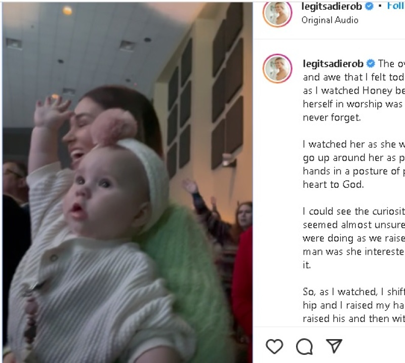 Baby Honey James Huff raising her hand in church during worship